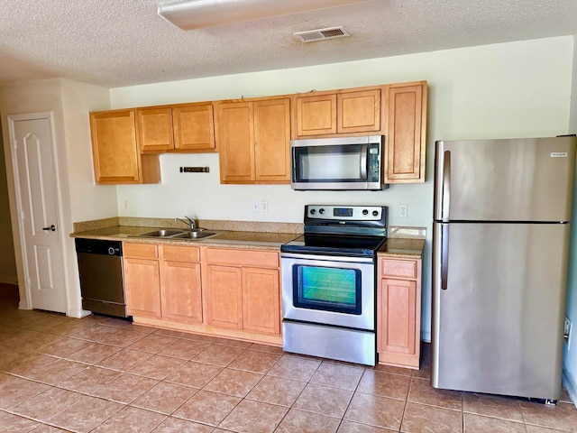 3000 S Adams St Unit 234, Tallahassee, FL 32301 - kitchen with appliances with stainless steel finishes, a sink, a textured ceiling, and light tile patterned floors