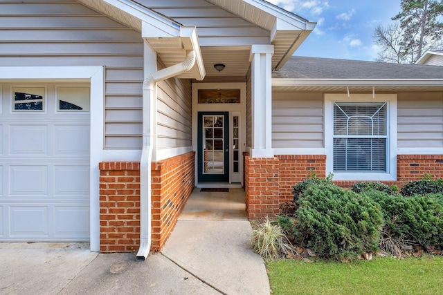 property entrance with an attached garage, roof with shingles, and brick siding