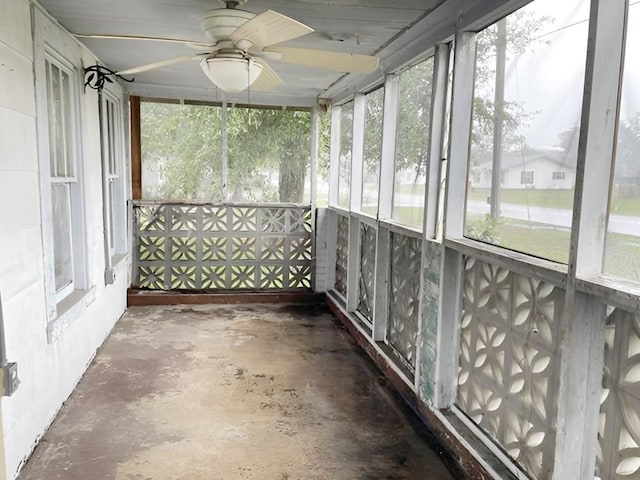 unfurnished sunroom with ceiling fan