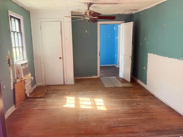 spare room featuring ceiling fan, cooling unit, and wood-type flooring