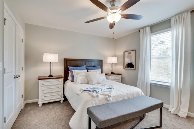 carpeted bedroom with ceiling fan and multiple windows