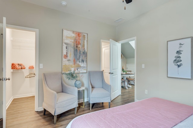 bedroom featuring wood-type flooring and a spacious closet