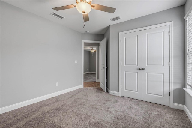 unfurnished bedroom featuring carpet floors, baseboards, visible vents, and a closet