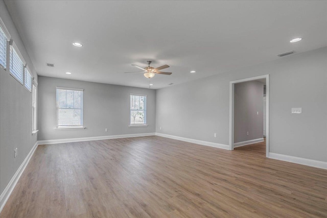 unfurnished room featuring recessed lighting, wood finished floors, visible vents, and baseboards