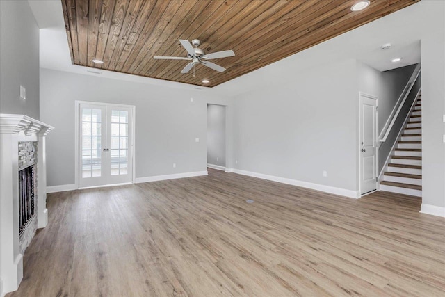 unfurnished living room with wood ceiling, a fireplace, wood finished floors, and french doors