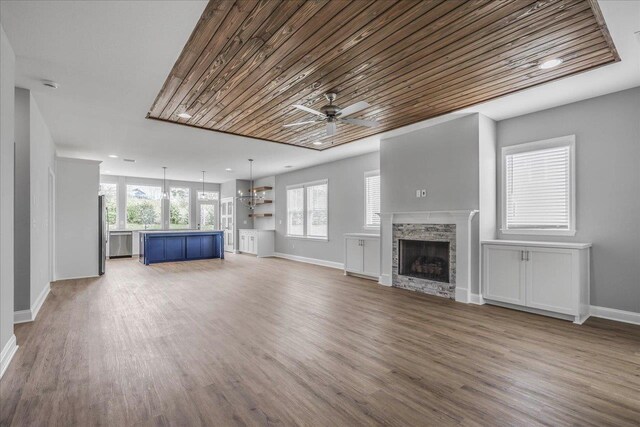 unfurnished living room featuring a fireplace, a ceiling fan, wood ceiling, wood finished floors, and baseboards