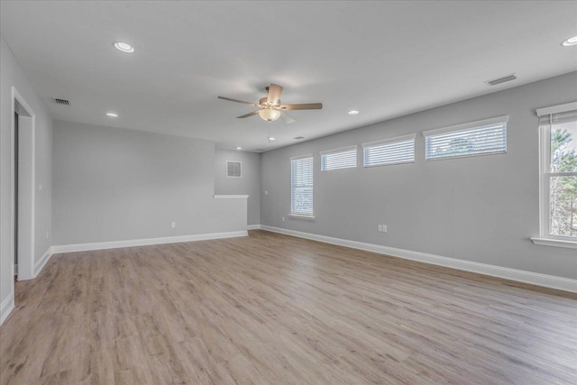 empty room featuring light wood-type flooring, baseboards, and recessed lighting