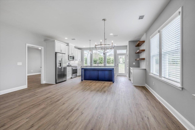 kitchen featuring stainless steel appliances, light countertops, white cabinetry, and baseboards