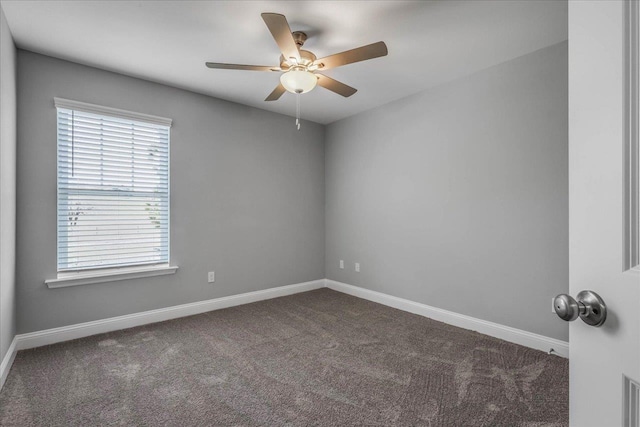empty room featuring visible vents, dark carpet, baseboards, and ceiling fan