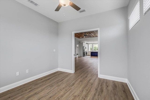 spare room featuring wood finished floors, visible vents, and baseboards