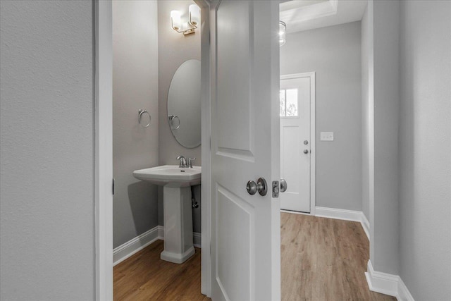 bathroom with baseboards and wood finished floors