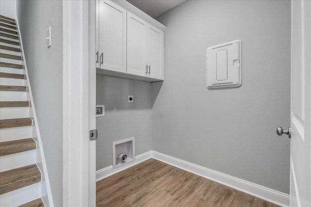 clothes washing area with cabinet space, baseboards, wood finished floors, washer hookup, and electric dryer hookup