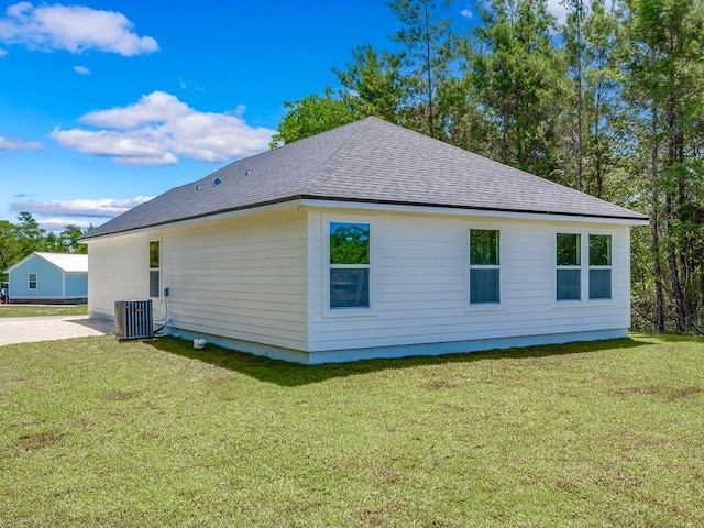 view of side of home with a lawn and central air condition unit