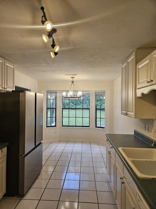 2305 Carrick Ct, Tallahassee, FL 32309 - kitchen with freestanding refrigerator, dark countertops, plenty of natural light, and light tile patterned flooring