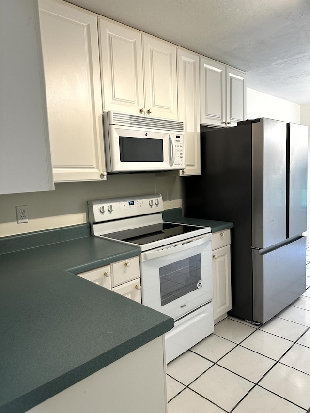 2305 Carrick Ct, Tallahassee, FL 32309 - kitchen with white appliances, dark countertops, white cabinetry, and light tile patterned flooring