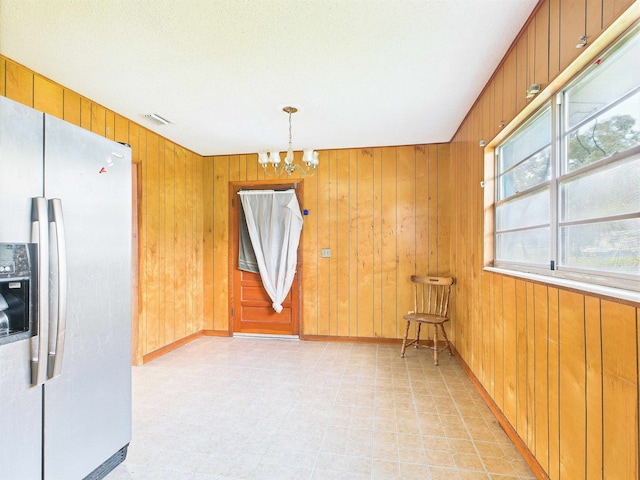 302 Goff St, Perry, FL 32347 - unfurnished dining area with a chandelier, wooden walls, and light flooring