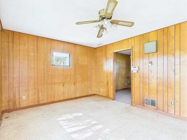 302 Goff St, Perry, FL 32347 - empty room with tile patterned floors, wooden walls, and ceiling fan