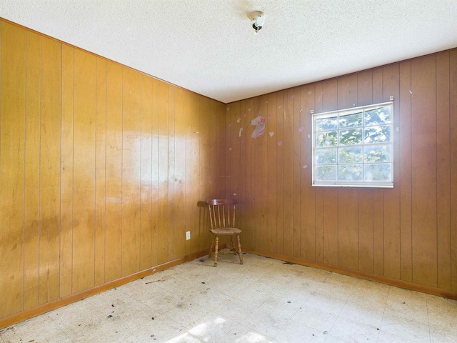 302 Goff St, Perry, FL 32347 - spare room featuring tile patterned floors, wood walls, and a textured ceiling