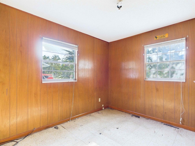 302 Goff St, Perry, FL 32347 - spare room featuring healthy amount of natural light, tile patterned floors, and wood walls