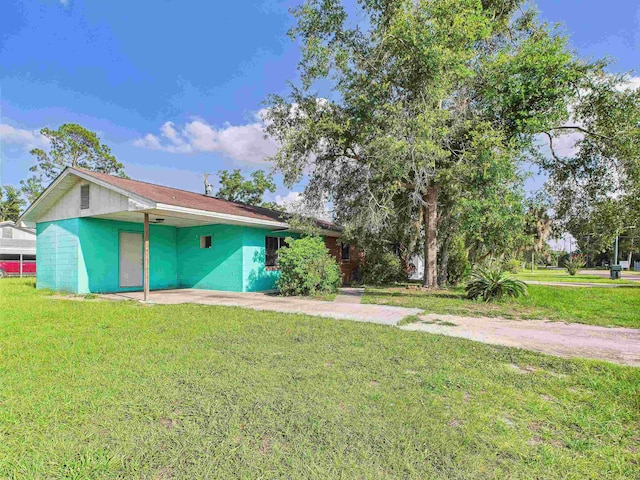 302 Goff St, Perry, FL 32347 - view of side of property with a carport, a lawn, and driveway