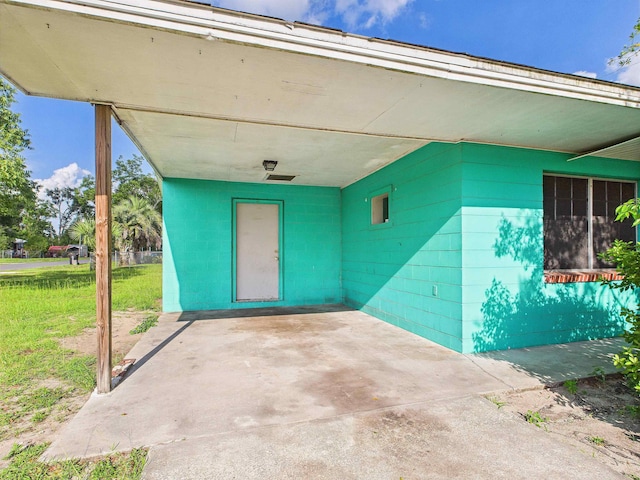 302 Goff St, Perry, FL 32347 - doorway to property with a patio, an attached carport, and concrete block siding