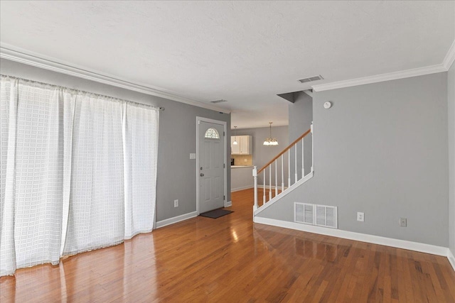 2965 N Shamrock, Tallahassee, FL 32309 - empty room featuring stairs, crown molding, wood finished floors, and a chandelier