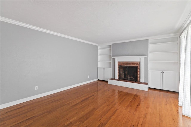 2965 N Shamrock, Tallahassee, FL 32309 - unfurnished living room featuring wood finished floors, built in features, a brick fireplace, and ornamental molding