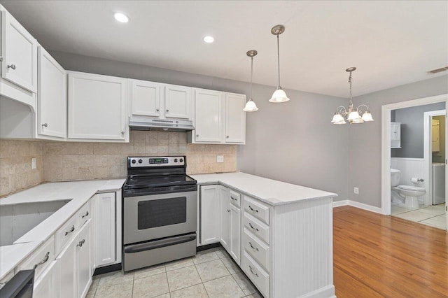 2965 N Shamrock, Tallahassee, FL 32309 - kitchen with electric stove, under cabinet range hood, a peninsula, white cabinets, and decorative backsplash