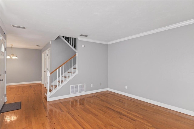 2965 N Shamrock, Tallahassee, FL 32309 - empty room with stairway, a chandelier, wood finished floors, and ornamental molding