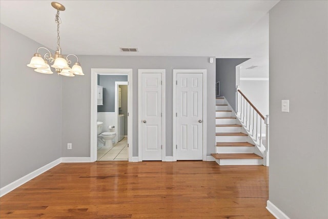 2965 N Shamrock, Tallahassee, FL 32309 - spare room with a chandelier, wood finished floors, and stairway