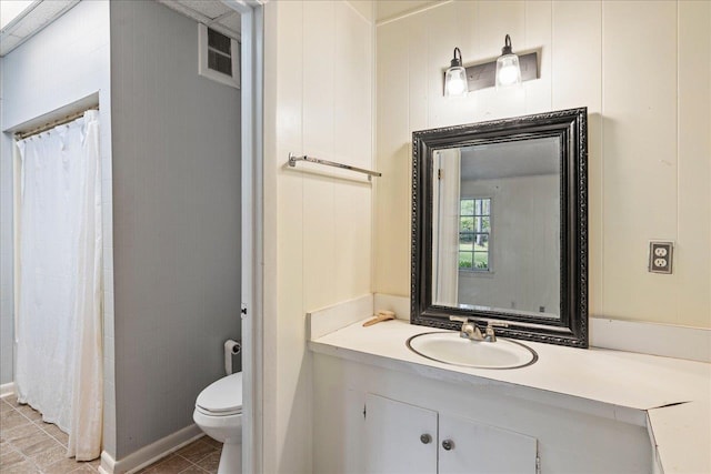 bathroom with vanity, walk in shower, tile patterned floors, and toilet