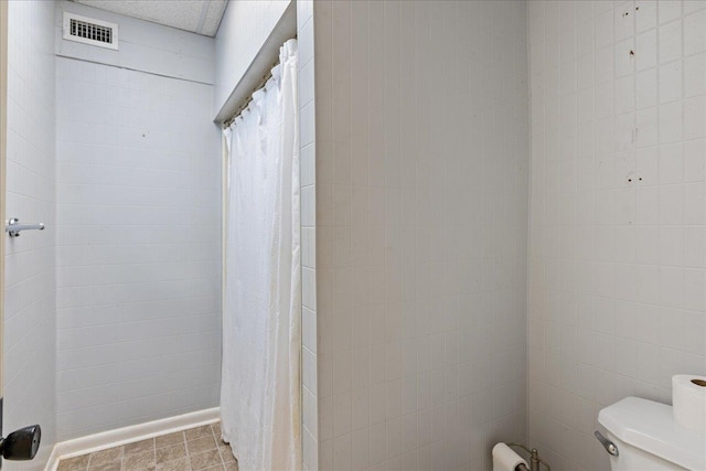 bathroom with curtained shower and toilet