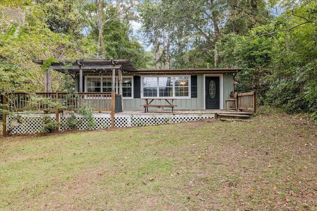 back of house with a lawn, a wooden deck, and a pergola