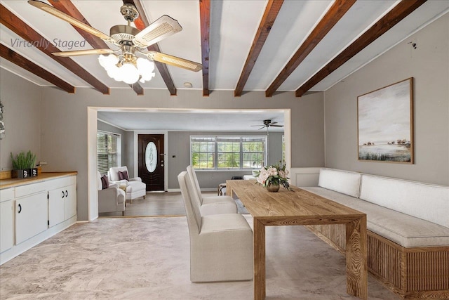 dining space with ceiling fan and beam ceiling