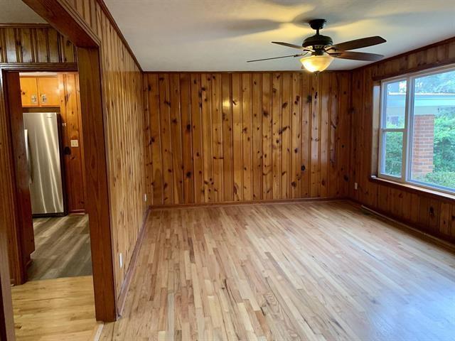 1915 Sunset Ln, Tallahassee, FL 32303 - spare room with ceiling fan, light wood finished floors, and wooden walls