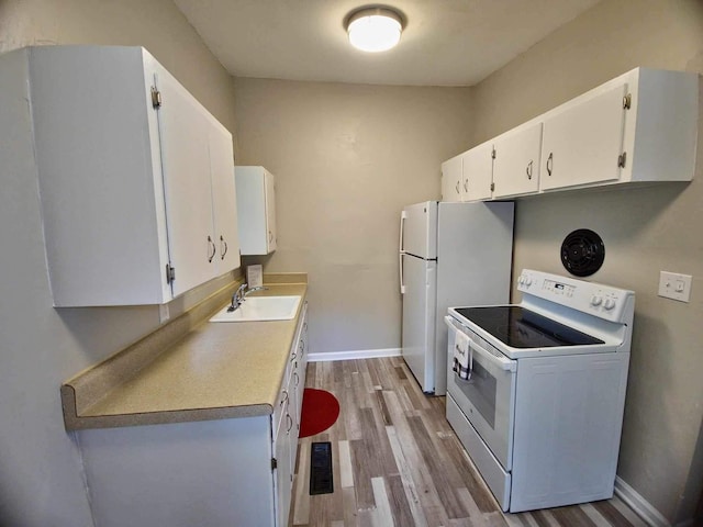 2031 Holmes St, Tallahassee, FL 32310 - kitchen with white appliances, baseboards, light wood-type flooring, white cabinetry, and a sink