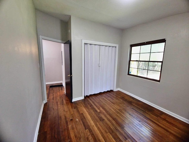 2031 Holmes St, Tallahassee, FL 32310 - unfurnished bedroom featuring dark wood-style floors, a closet, and baseboards