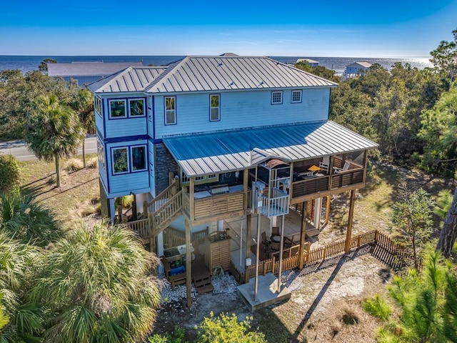 641 Bald Point Rd, Alligator Point, FL 32346 - rear view of house featuring metal roof, a patio area, a standing seam roof, a deck with water view, and stairway