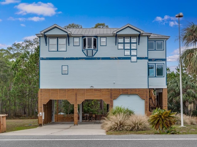 641 Bald Point Rd, Alligator Point, FL 32346 - view of front of house with a carport, stairway, metal roof, and a standing seam roof