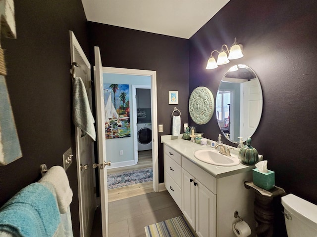 bathroom featuring washer / dryer, tile patterned flooring, toilet, and vanity