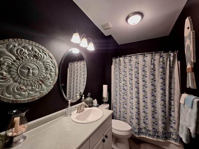 full bath with curtained shower, toilet, and vanity