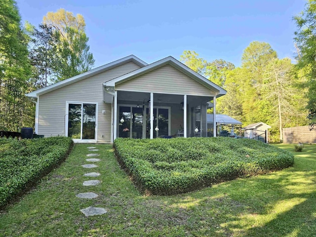 back of property featuring a lawn and a sunroom