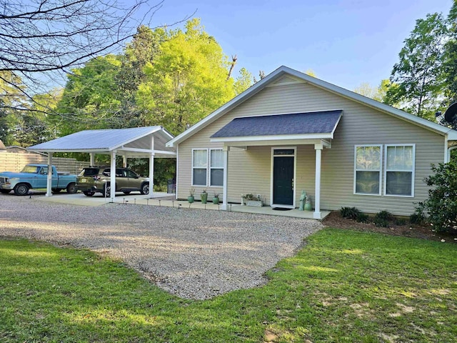 view of front of house featuring driveway, a front lawn, and roof with shingles