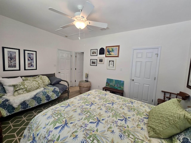 bedroom featuring wood finished floors, visible vents, and a ceiling fan