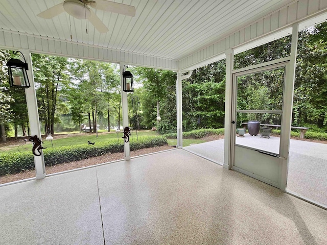 unfurnished sunroom featuring a wealth of natural light and a ceiling fan