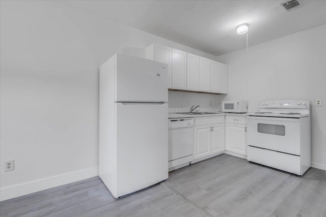 1317 Airport Dr Unit F12, Tallahassee, FL 32304 - kitchen with white appliances, light wood-style floors, light countertops, white cabinets, and a sink