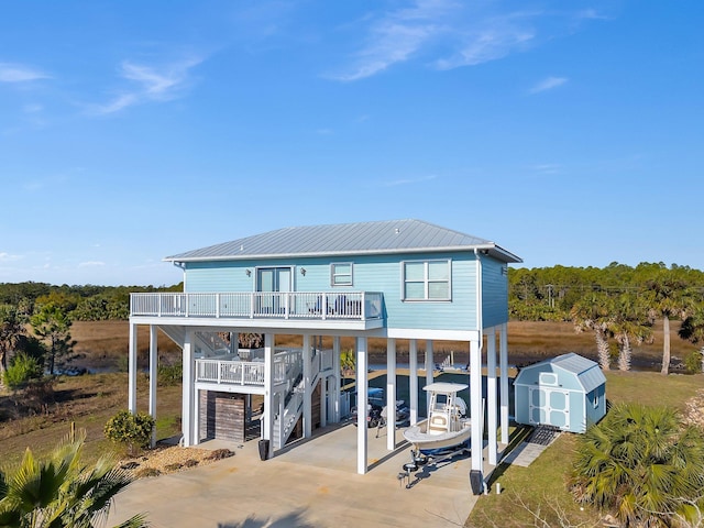 rear view of house with a carport, a water view, and a storage shed