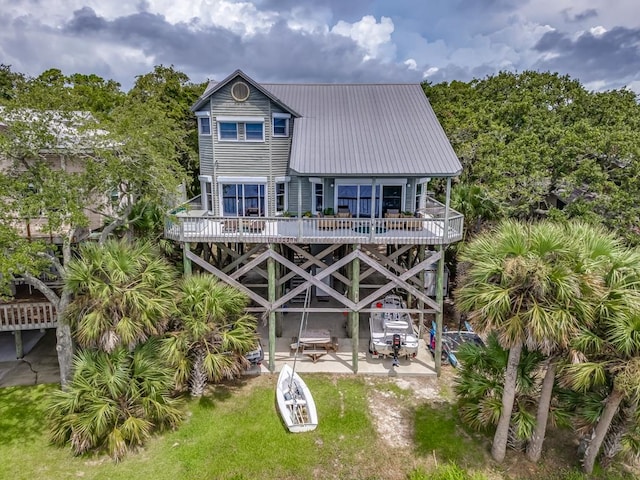 back of house featuring a patio, a fire pit, and a wooden deck