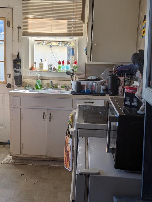 kitchen featuring plenty of natural light, white cabinets, and sink