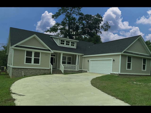 view of front facade featuring a front lawn, a garage, and a porch